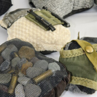Stones and pebbles, fabric, bullet casings, remnants of M16 military pouches, fiberglass screening, thread. Dimensions variable, 2009