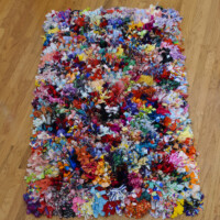 Recycled fabric, 384 rabbits' feet, waxed twine, thread, canvas backing. 6"H x 44"W x 73"D, 2010