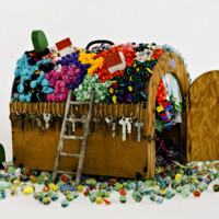Found pet carrier (wood, masonite and chicken wire, w/metal handle), fabric, newspaper, used keys, key chains, yarn and thread remnants, wooden toy houses and tree, toy ladder, wooden Tinkertoy parts, cats' eye marbles, 14"H x 28"W x 24"D, 2012